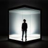 Silhouetted Person in Illuminated Glass Cube